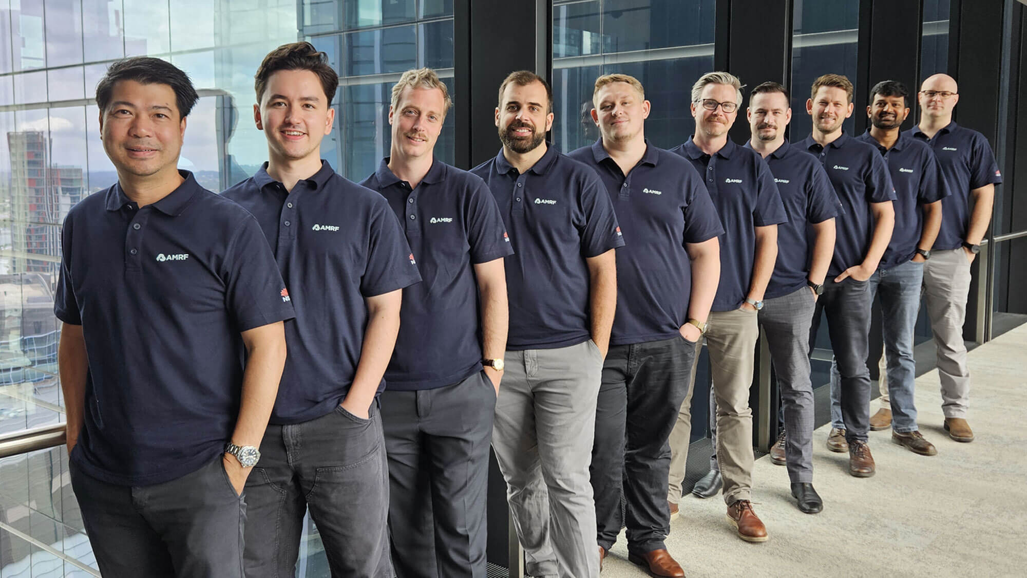 The 10 members of the AMRF technical team lined up in front of a window, wearing matching AMRF shirts.